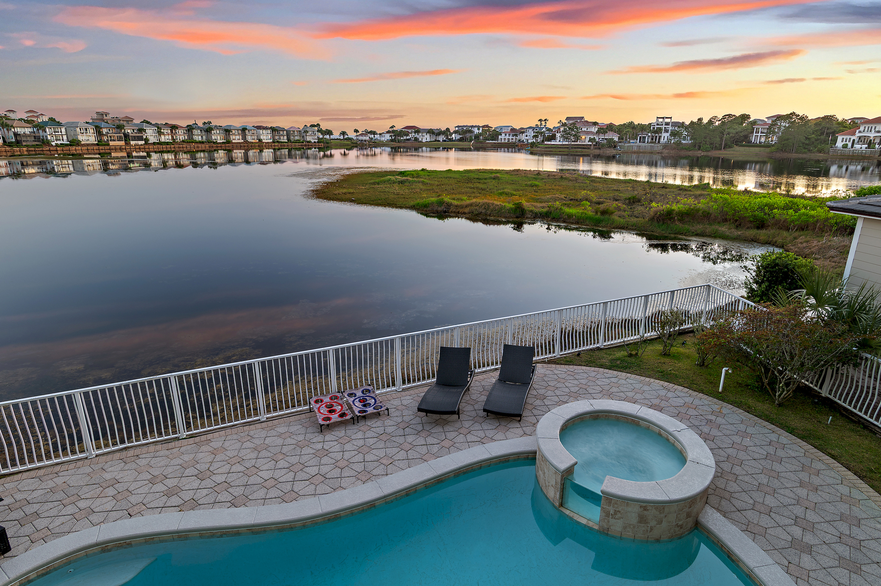 Sunset over the private lake and pool at Destin To Relax